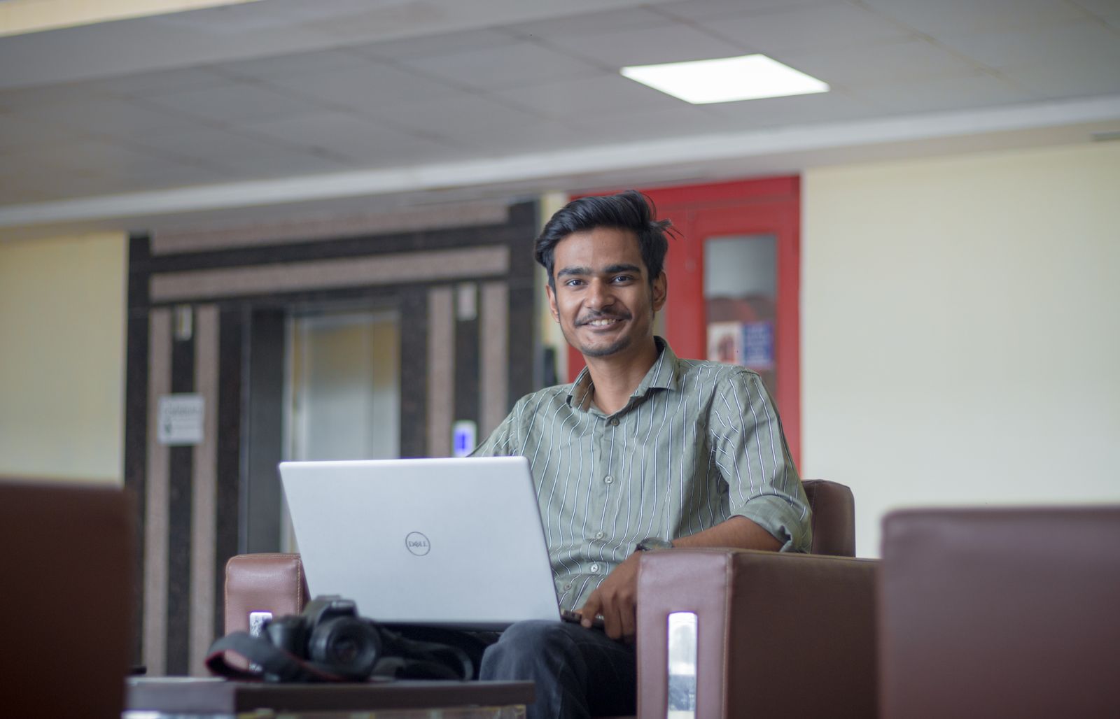 A young Indian professional working on a laptop
