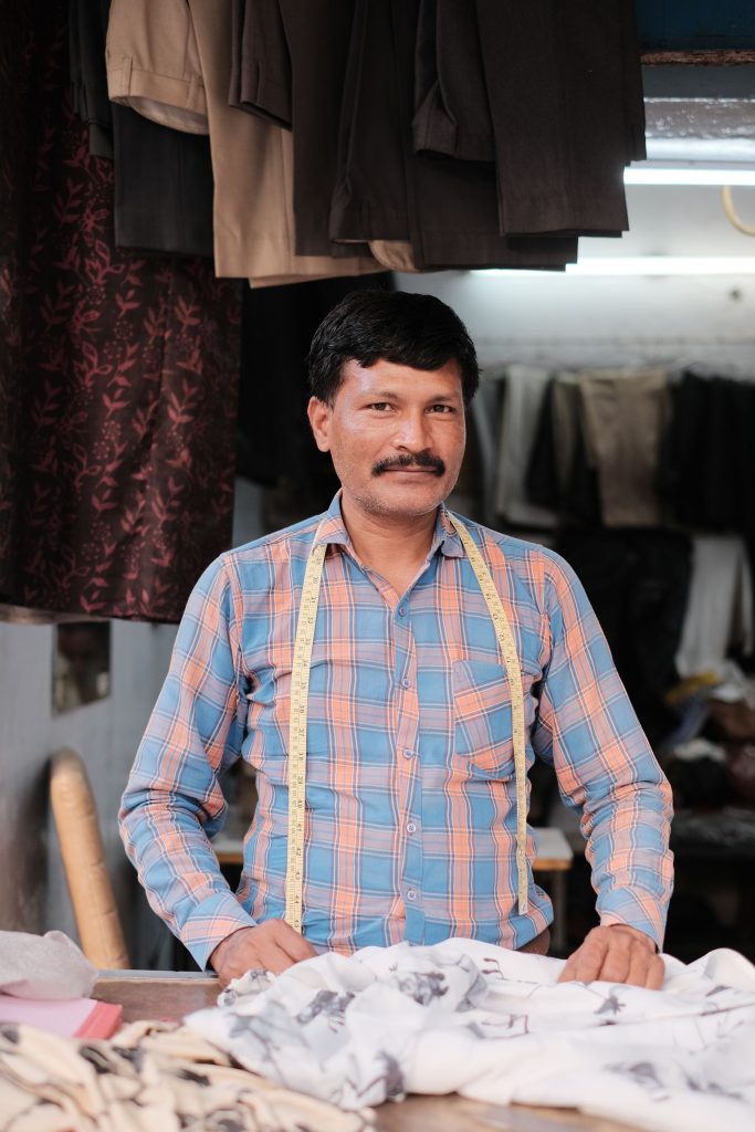 A tailor standing in his own workshop in New Delhi