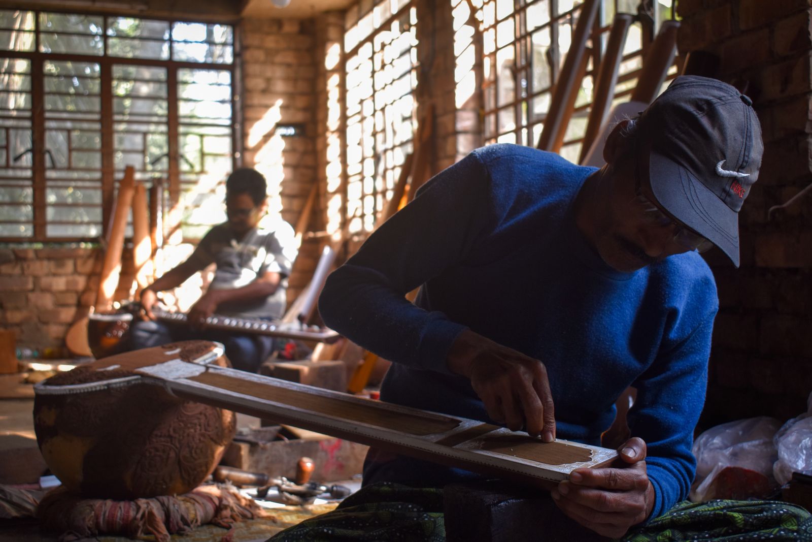 Two artisans making musical instruments in a workshop in Kolkata