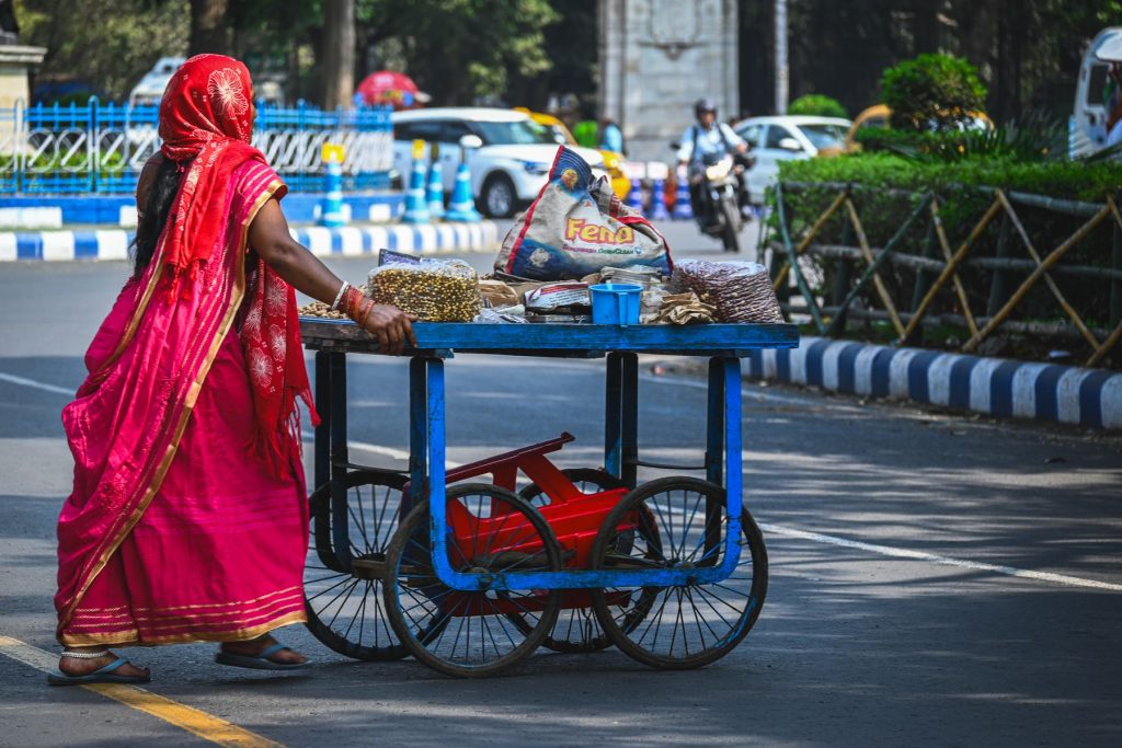 A vendor pushing her cart through a street in Kolkata