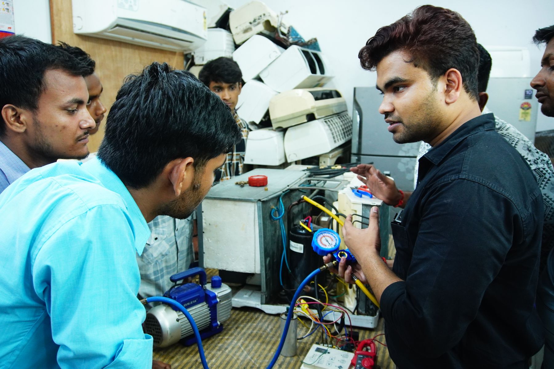 Trainees at a hands-on air-conditioning repair session in India