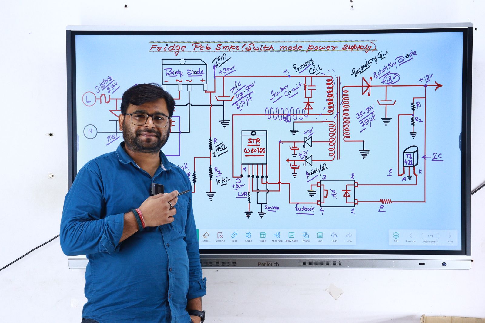 An instructor in New Delhi teaching electronics from a circuit diagram on screen