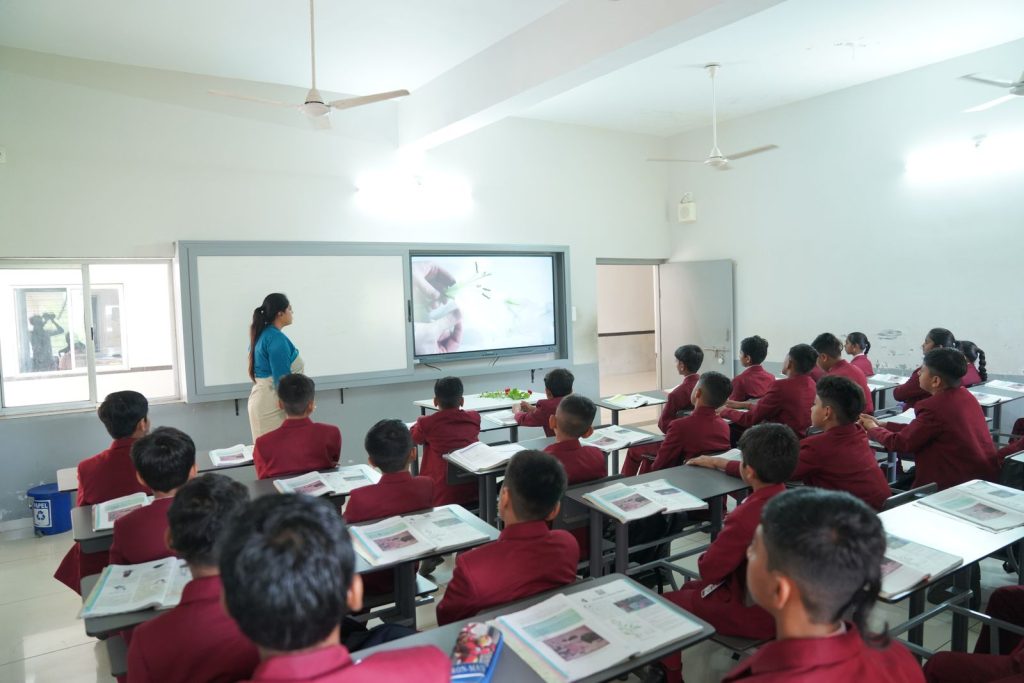 Students in a modern classroom with an interactive display in Petlad, Gujarat