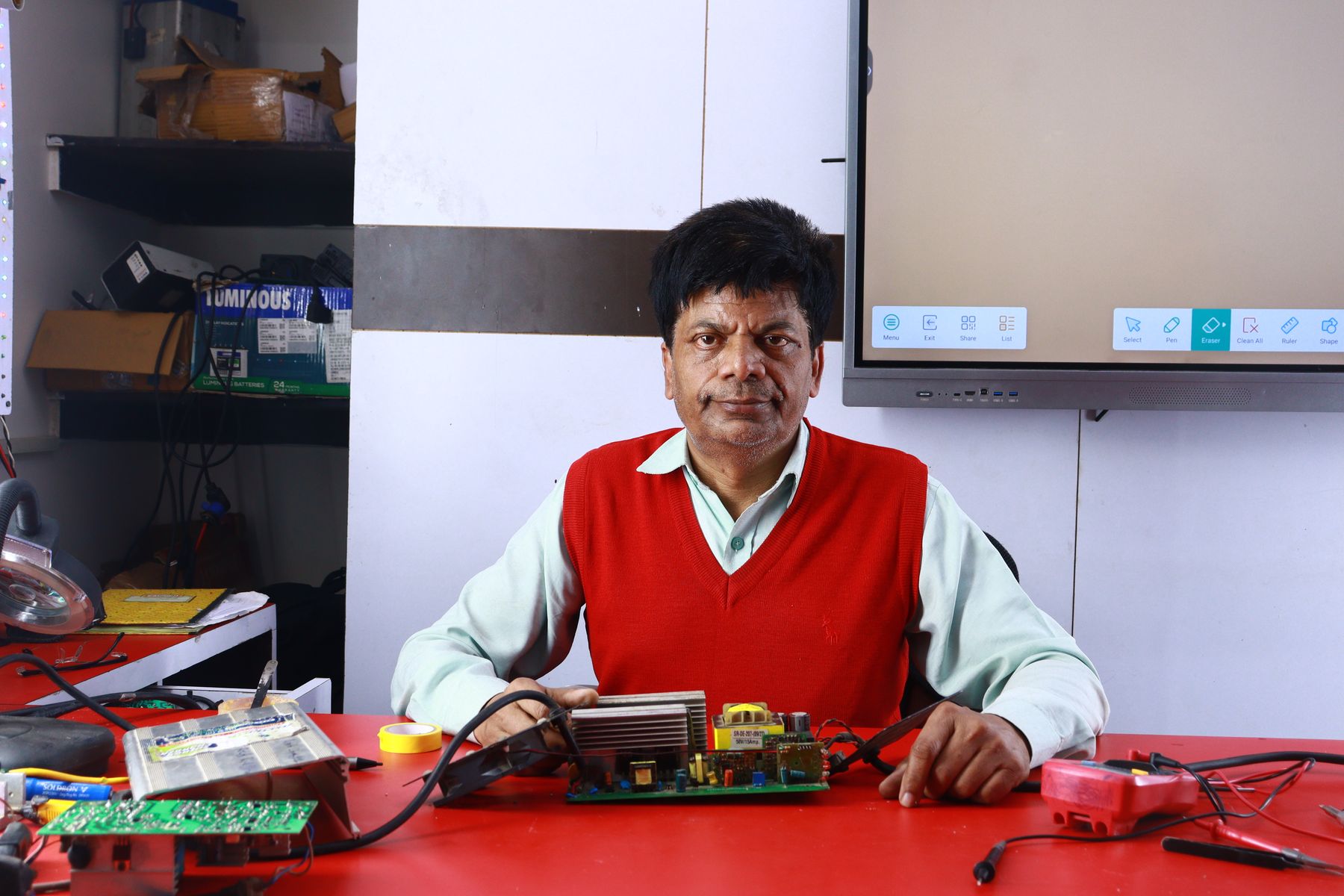 An instructor teaching electronics repair at a training institute
