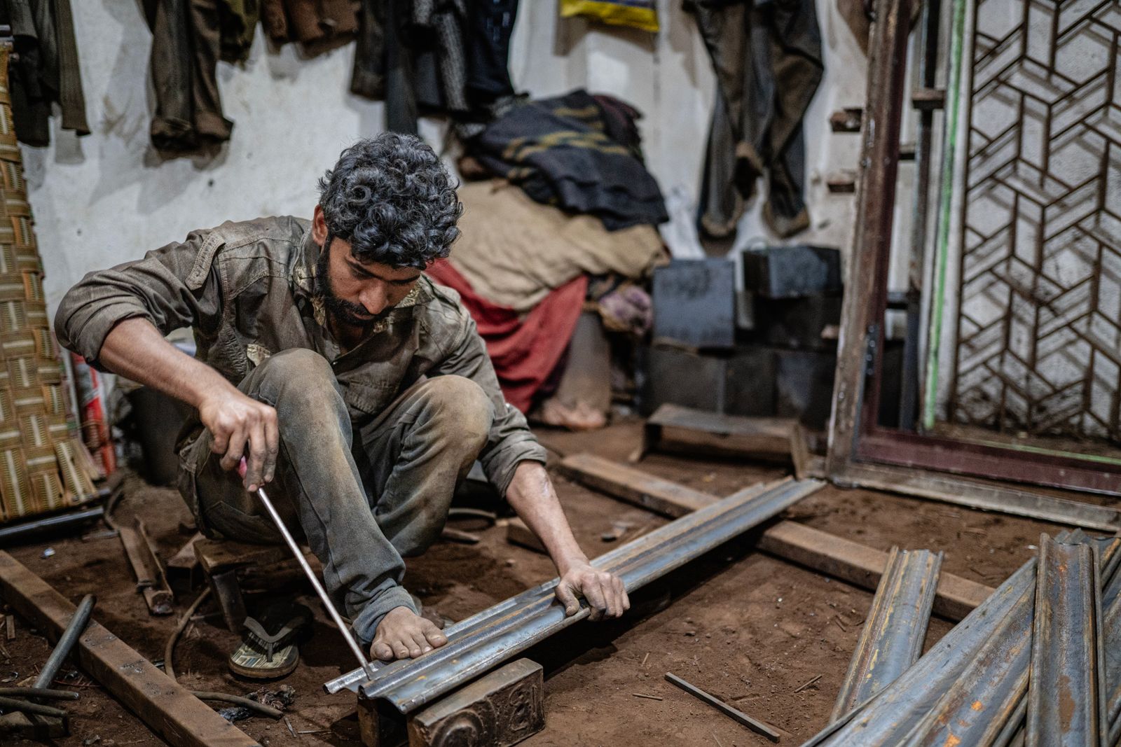 A craftsman at work on metal structures in a workshop in Varanasi, India