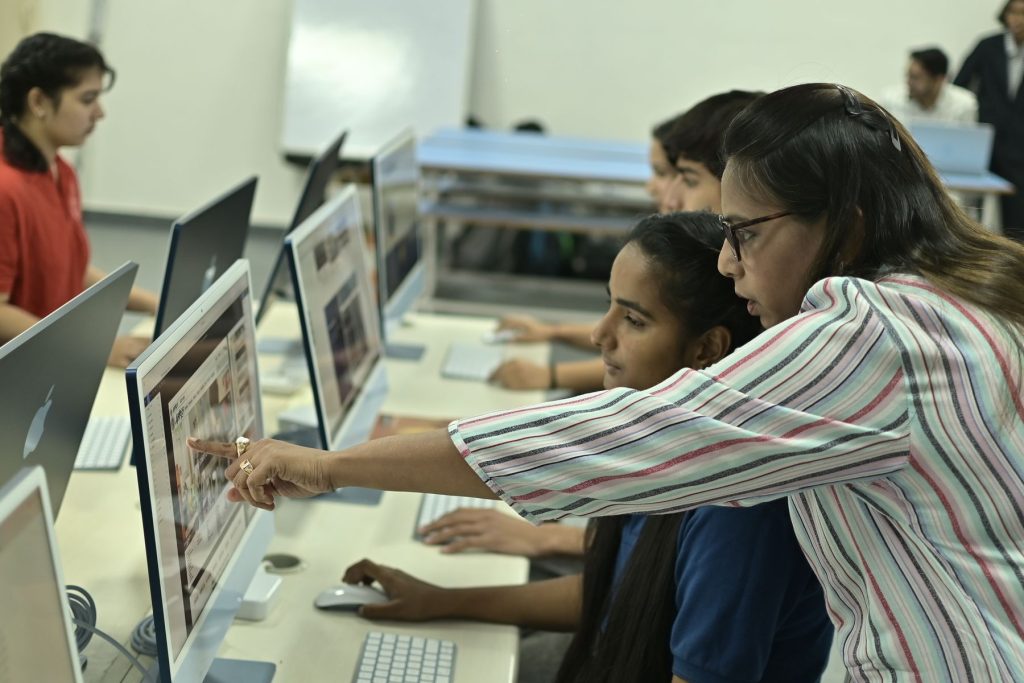 Students and an instructor working together in a computer lab in India