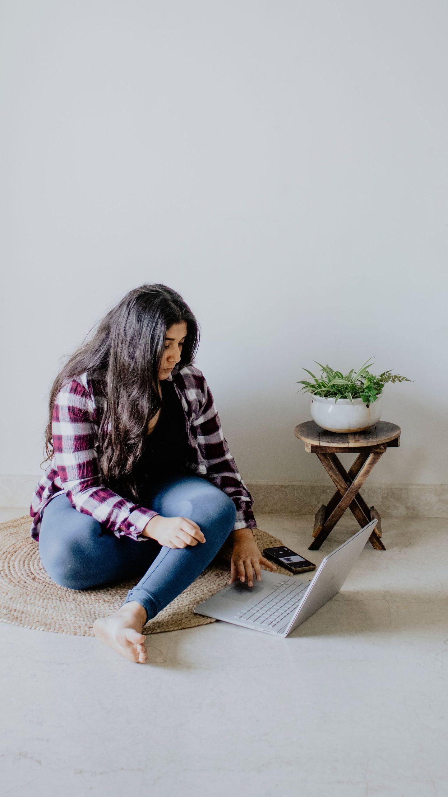 A young Indian woman working on a laptop at home