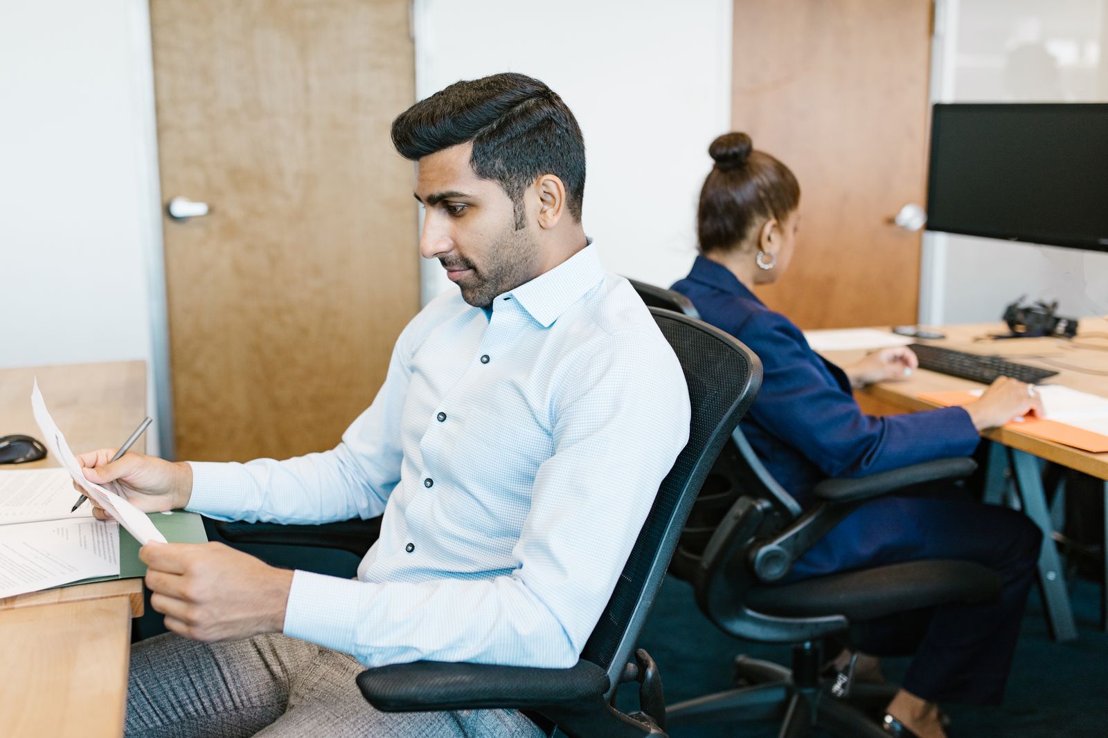 Two South Asian professionals working together in an office