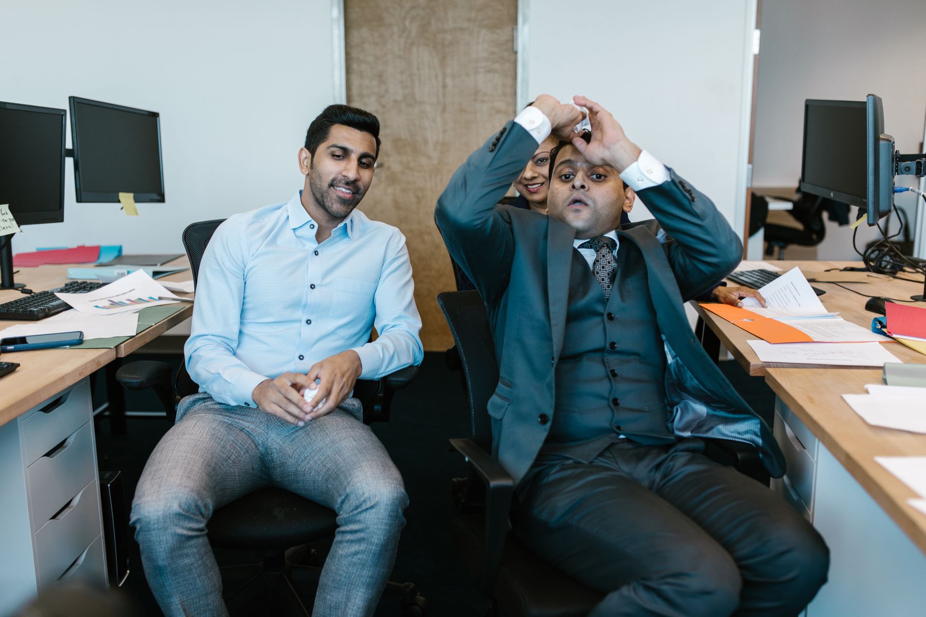 Two colleagues working together at computers in an office in India